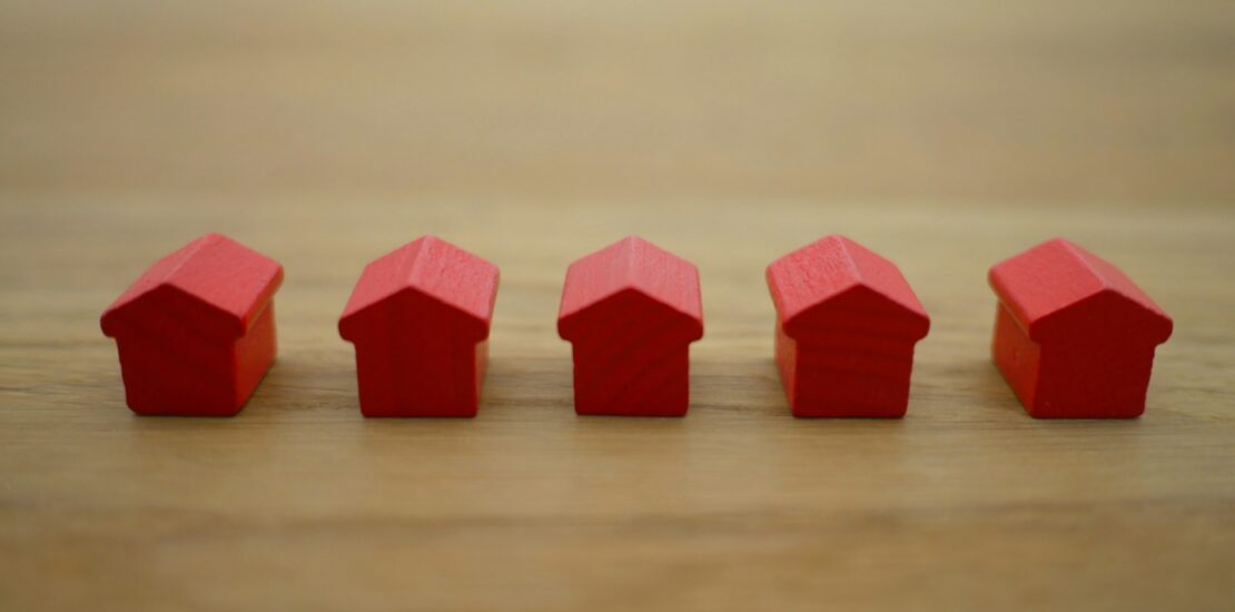 Red house models on wood table representing GTA homebuyers